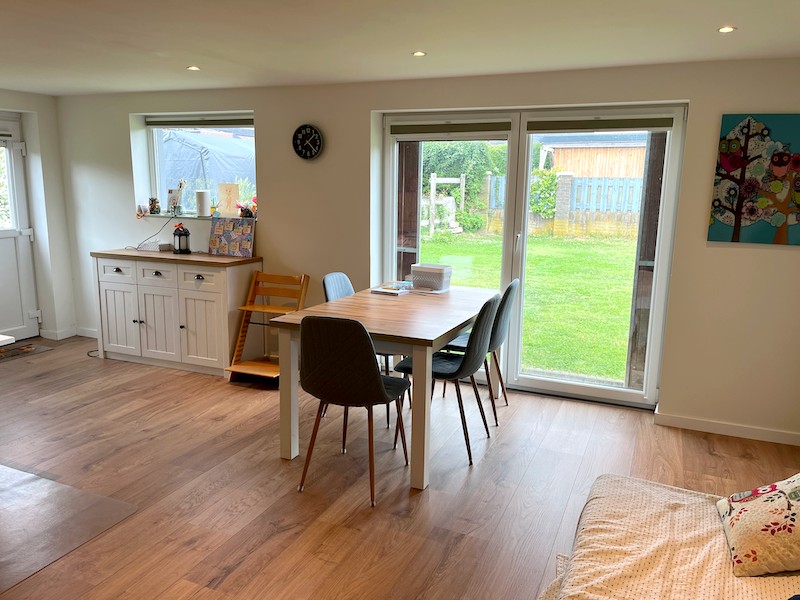 De tafel in de praktijkruimte met uitzicht op de tuin